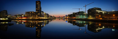 Looking up the River Liffey towards Dublin City Centre from the East Link Bridge at the end of a clear day in April. Sir John Rogerson’s Quay on the left bank; the Samuel Beckett Bridge straight ahead; and the National Convention Centre on the right with its blue bands.